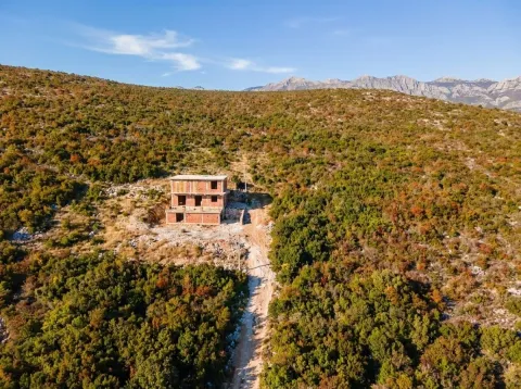 Pogled iz vazduha na nedovršenu kuću u prirodi okruženu rastinjem i planinama. - image 2