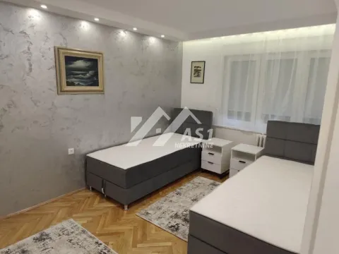 Nameštena spavaća soba sa dva kreveta i noćnim stočićima. - image 4