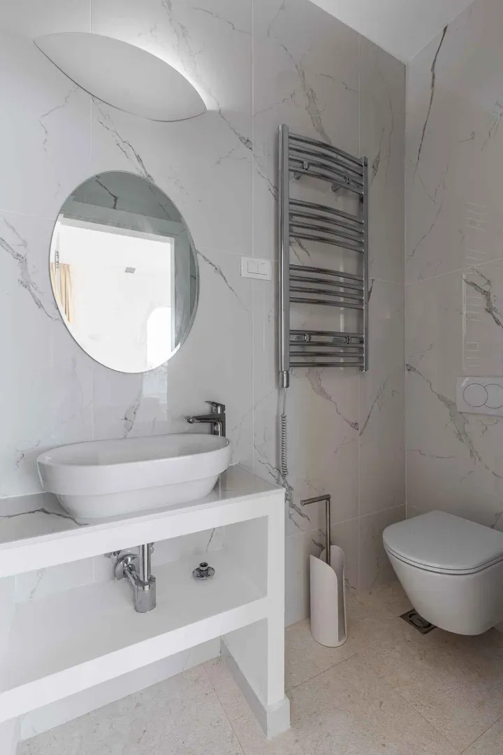 Moderne kupatilo sa umivaonikom, ogledalom i wc šoljom.