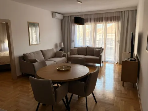 Living room with a dining table, seating furniture, and a television. - image 2