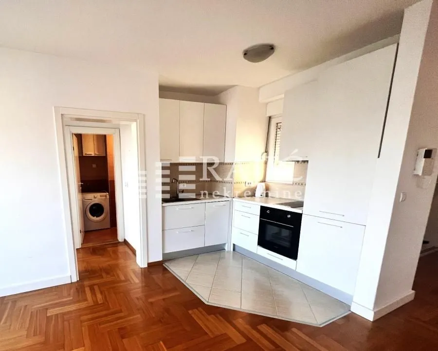 White kitchen with built-in appliances in the apartment.