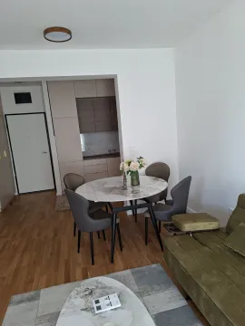 Bright living room with a dining table and kitchen in the background. - image 5