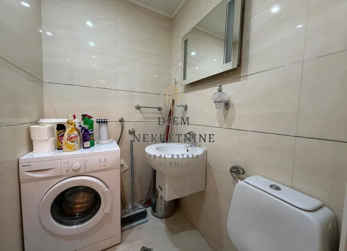 Bathroom with a washbasin, toilet, and washing machine.