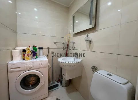 Bathroom with a washbasin, toilet, and washing machine. - image 12