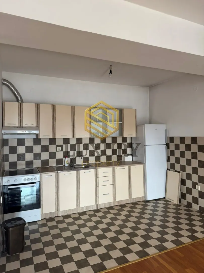 Smaller kitchen with cabinetry and white goods.