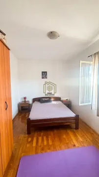 Spavaća soba sa bračnim krevetom, drvenim podom, ormarom i prozorom. - image 6