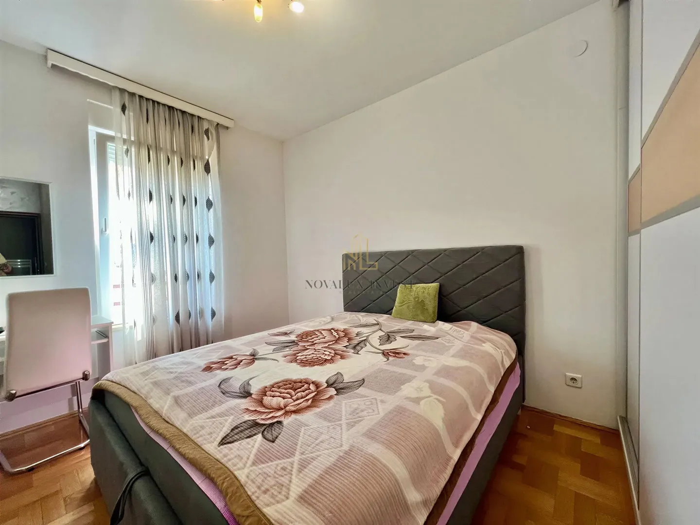 Furnished bedroom with a double bed, wardrobe, and desk.