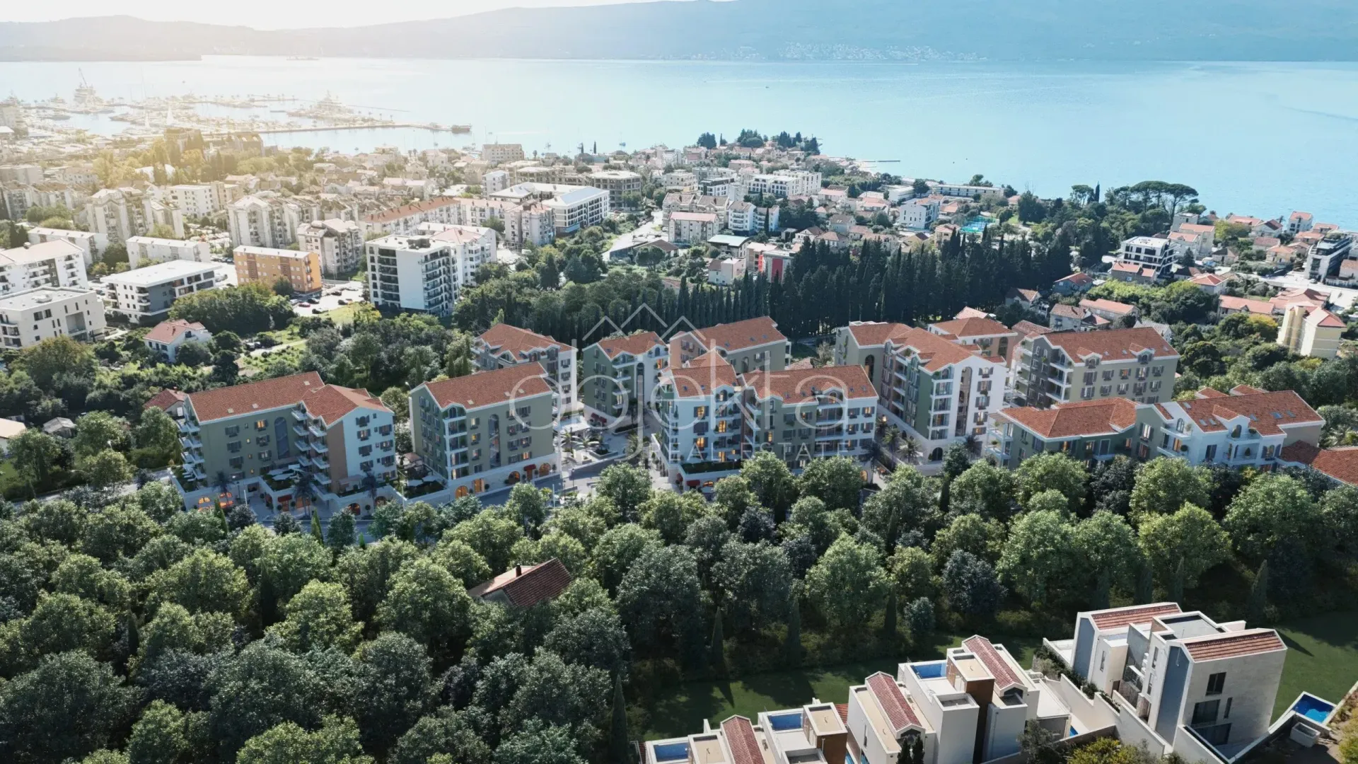 Pogled iz vazduha na stambeni kompleks sa zelenilom u blizini mora.