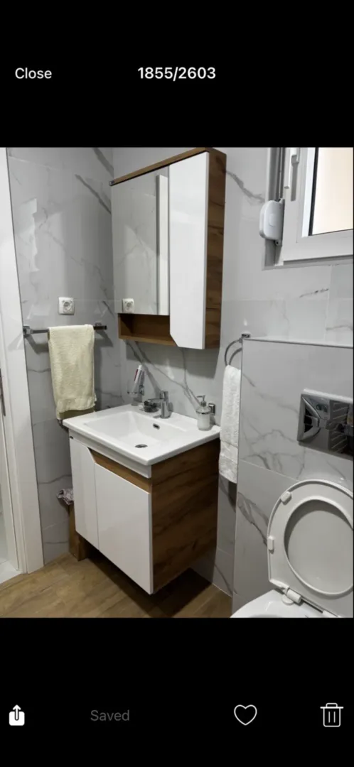 Moderne opremljeno kupatilo sa umivaonikom, ormarićem i WC šoljom.