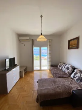Dnevna soba sa garniturom, TV-om i izlazom na terasu sa pogledom na more. - image 8