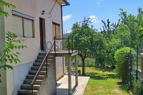 Eksterijer kuće sa spoljnim stepeništem, balkonom i dvorištem sa zelenilom. - image 6