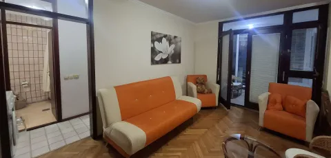 Dnevna soba sa garnITUrom u narandžastoj boji i pogledom na terasu. - image 6