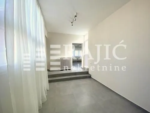Bright empty room with white walls and tiled flooring.