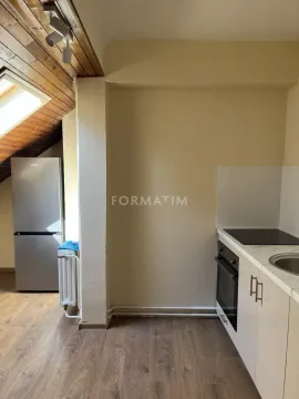 Small attic kitchen with wooden ceiling and white cabinets. - image 6