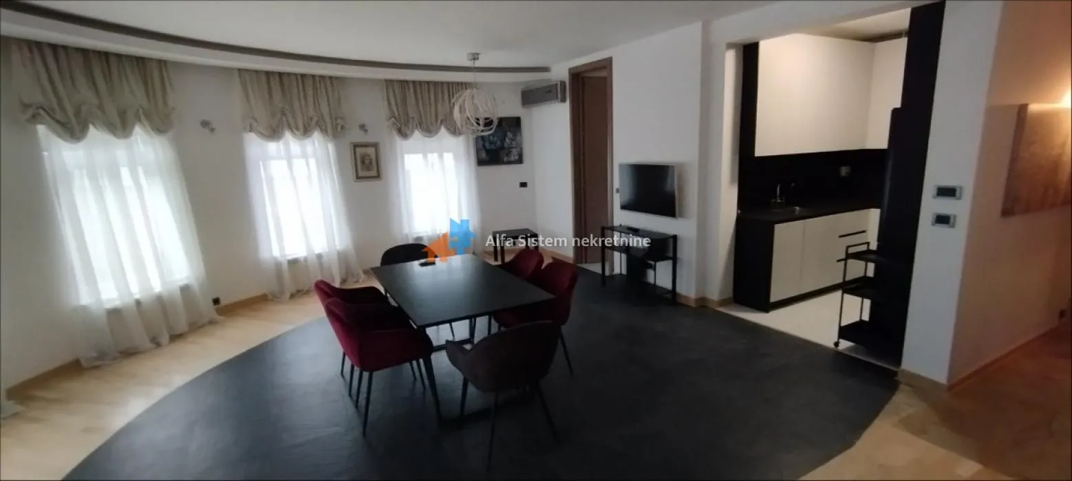 Dnevni boravak sa trpezarijom i otvorenim prolazom ka kuhinji.