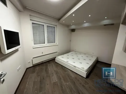 Furnished bedroom with a double bed and a wall-mounted TV. - image 11