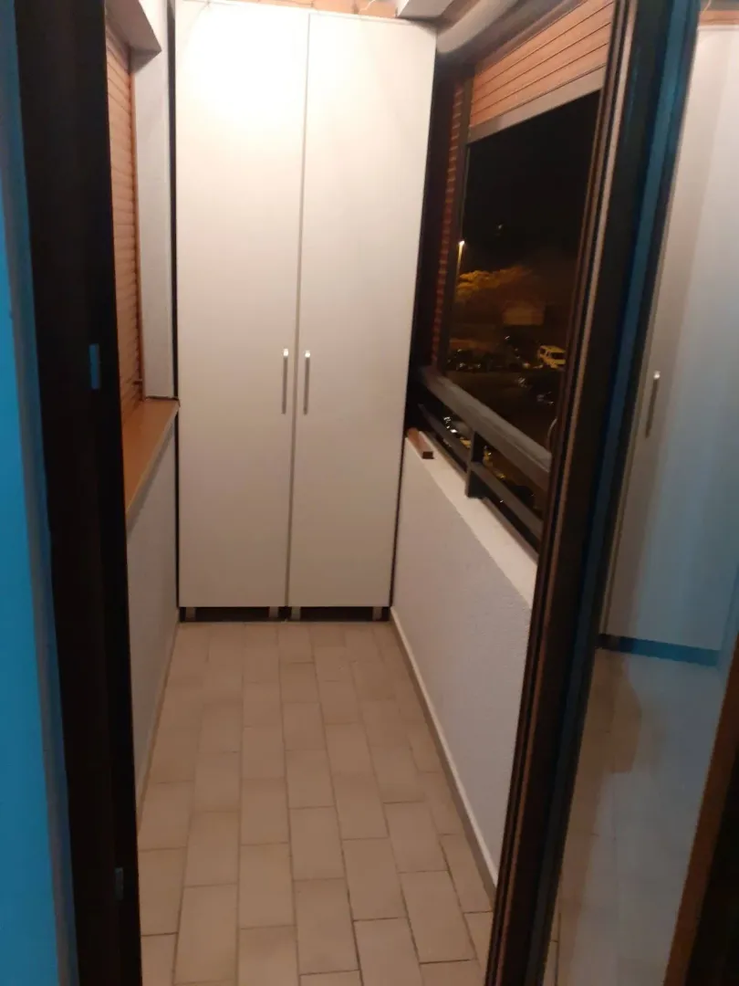 Closed balcony with a white wardrobe.