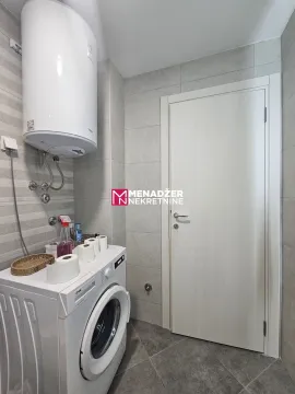 Kupatilo sa veš mašinom, bojlerom i bijelim vratima. - image 6