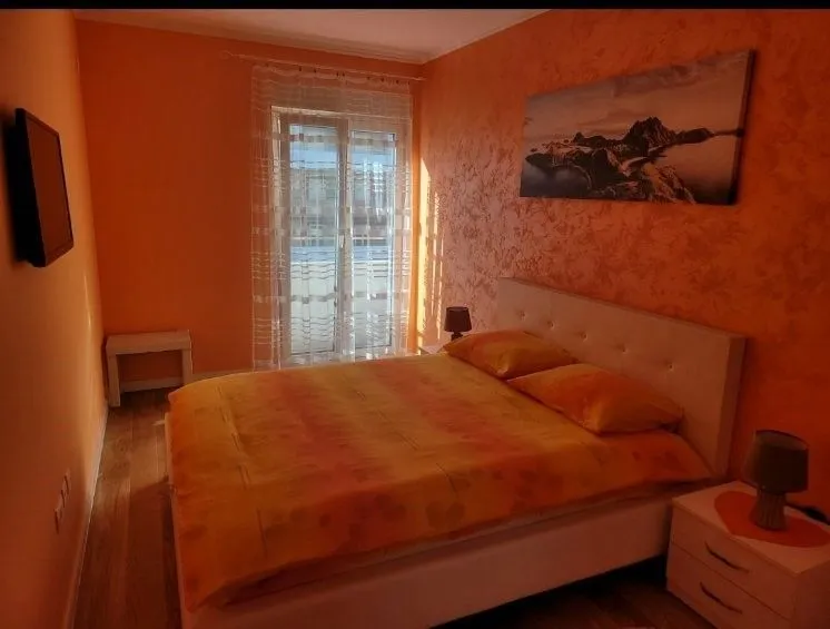 Bedroom with orange walls and a double bed.
