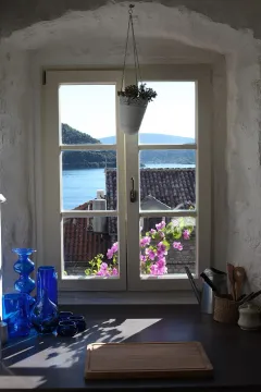 View through the kitchen window overlooking the sea and surrounding greenery. - image 5