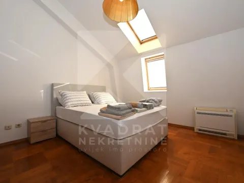 Bedroom with a double bed, skylight and wooden parquet flooring. - image 6