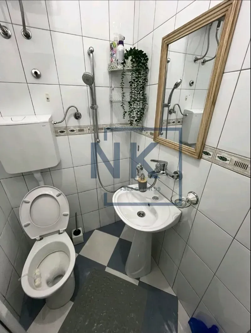 Manje kupatilo sa tuš kabinom, umivaonikom i toaletom.
