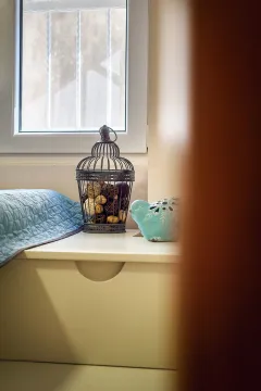 Detalj spavaće sobe sa ukrasnim predmetima pored prozora. - image 17
