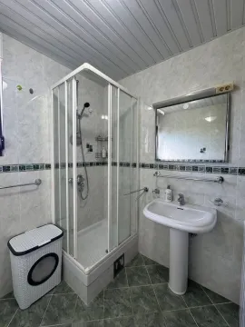 Kupatilo opremljeno tuš kabinom, umivaonikom i ogledalom. - image 14