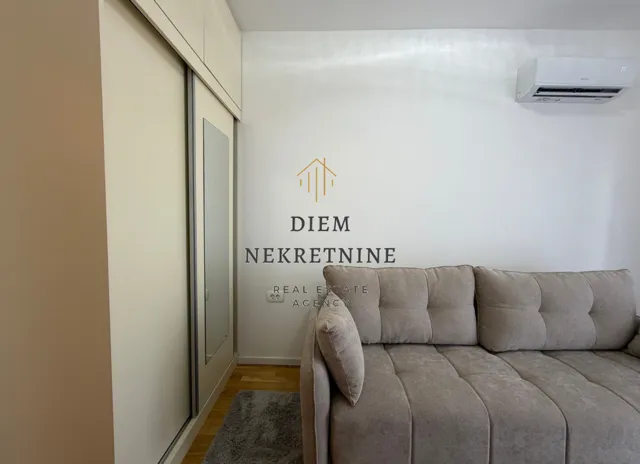 Living room with a beige sofa and built-in wardrobe.