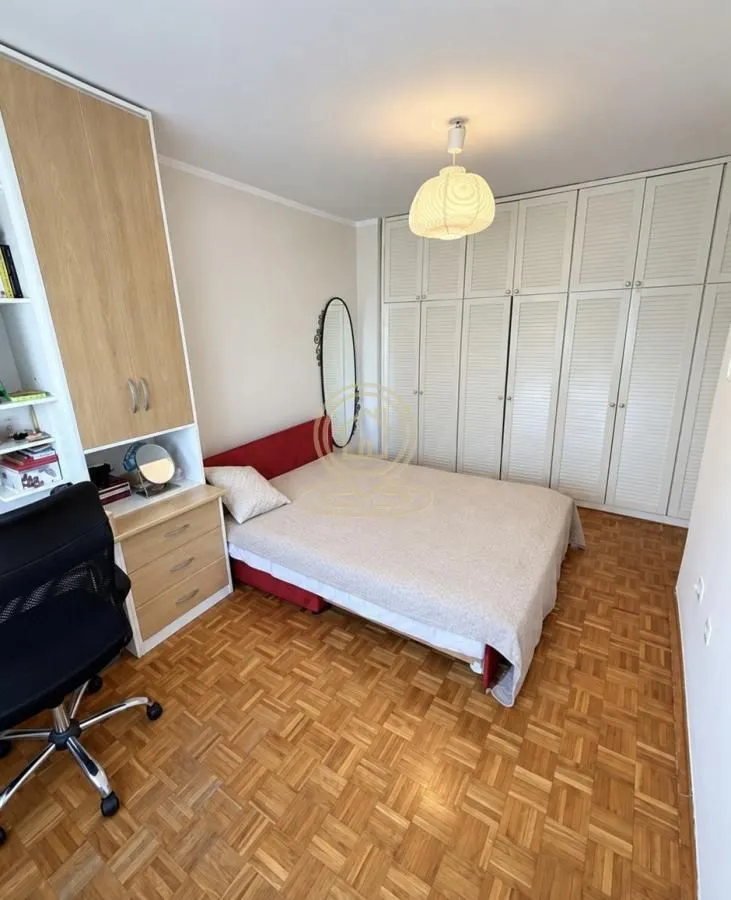Furnished bedroom with a double bed, desk, and fitted wardrobes.