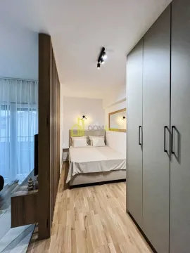 Modern bedroom with a double bed, fitted wardrobe and wooden partition. - image 7