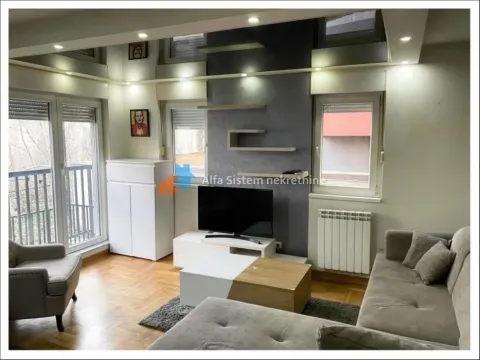 Furnished living room with a sofa, TV, and balcony access. - image 4