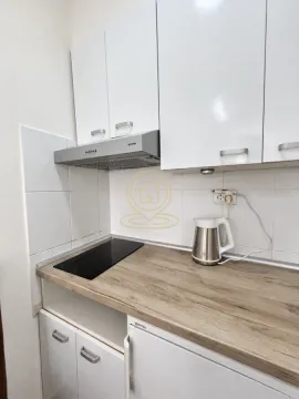 Small kitchen with white cabinets, wooden countertop and built-in cooktop. - image 6