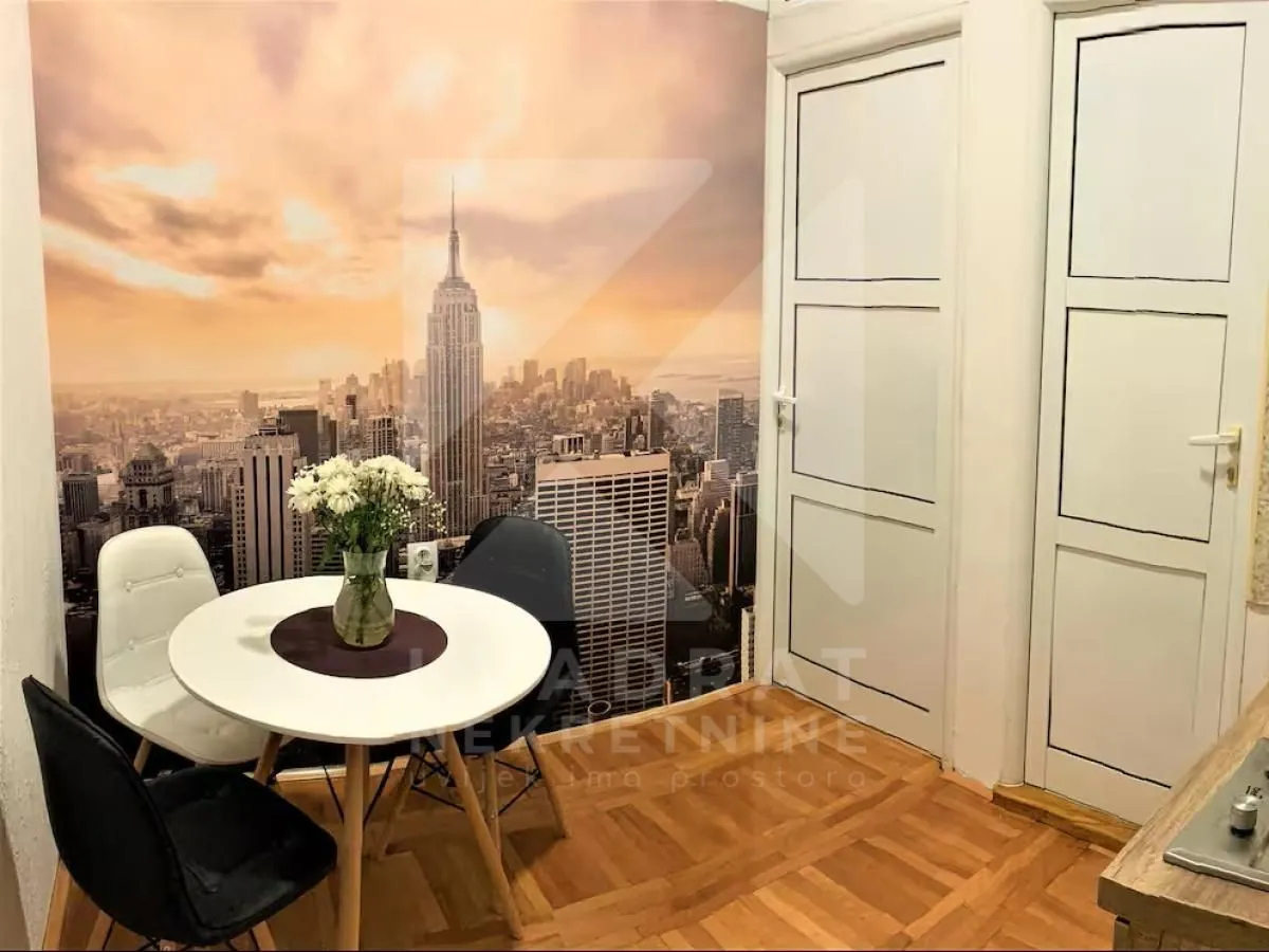 Dining table with chairs in front of wallpaper featuring a city motif.