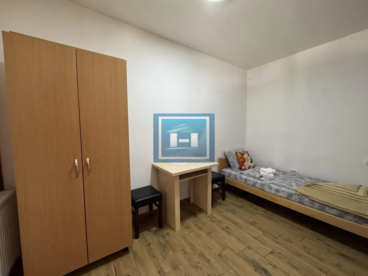 Small bedroom with a bed, wardrobe, and a desk.