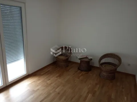 Dnevna soba sa drvenim podom i balkonskim vratima. - image 2