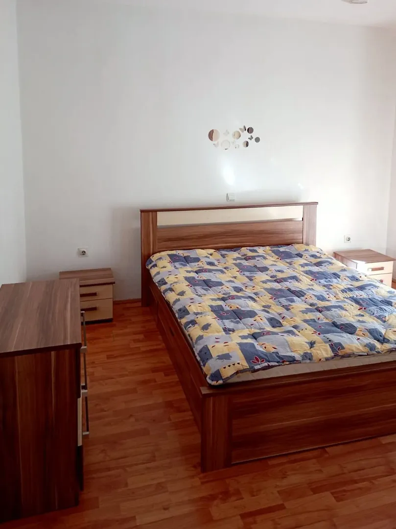 Bedroom with a double bed, bedside tables, and wooden flooring.