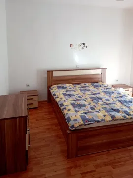Bedroom with a double bed, bedside tables, and wooden flooring. - image 9