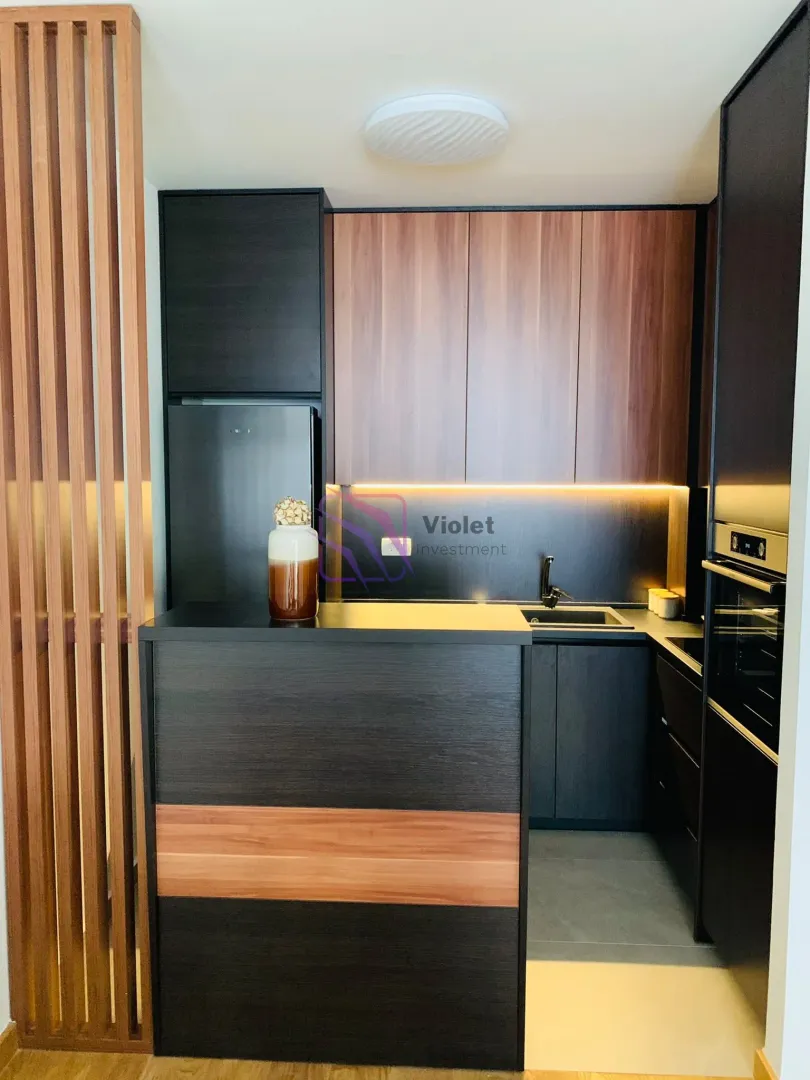 Modern kitchen with dark elements and wooden details.