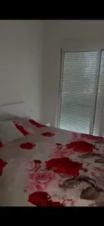 Spavaća soba sa bračnim krevetom i balkonskim vratima.