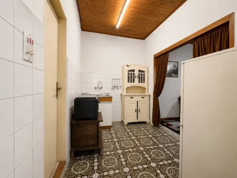 Starija kuhinja sa drvenim elementima i keramičkim pločicama. - image 7