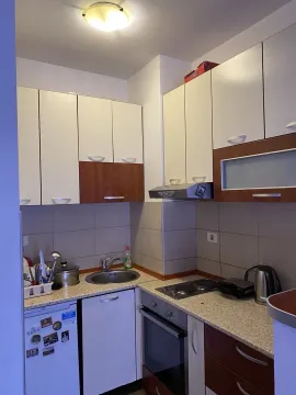 A small kitchen with white and brown cabinets. - image 7