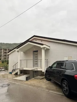 Eksterijer kuće sa ulaznim trijemom i parkiranim automobilom u dvorištu. - image 2