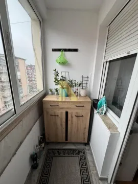 Zastakljeni balkon sa drvenim ormarićem i biljkama. - image 30