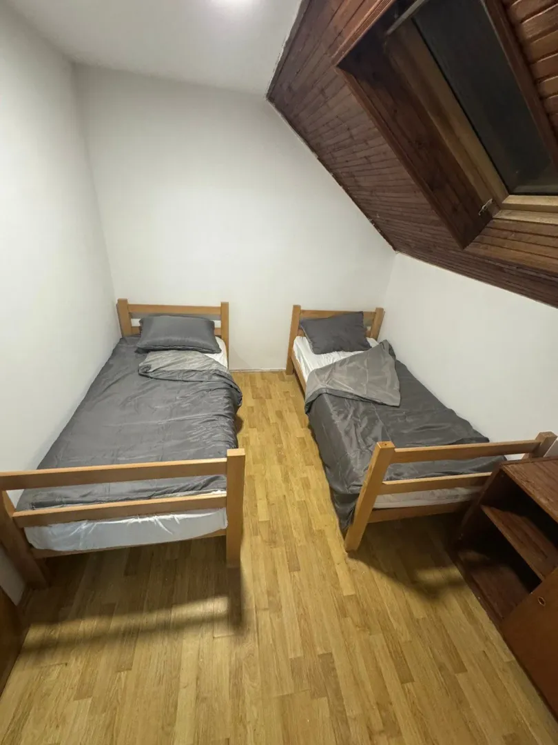 Attic bedroom with two single beds and a skylight window.