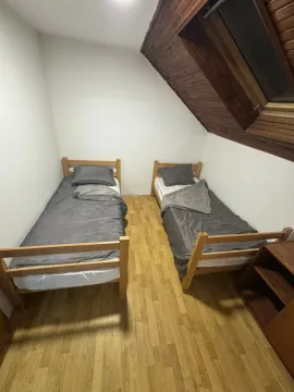 Attic bedroom with two single beds and a skylight window. - image 6