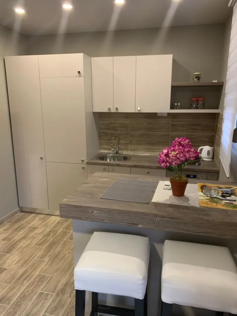 Small modern kitchen with a breakfast bar and white cabinetry.