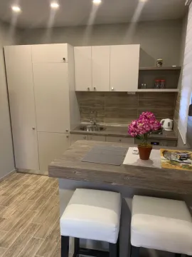 Small modern kitchen with a breakfast bar and white cabinetry. - image 3