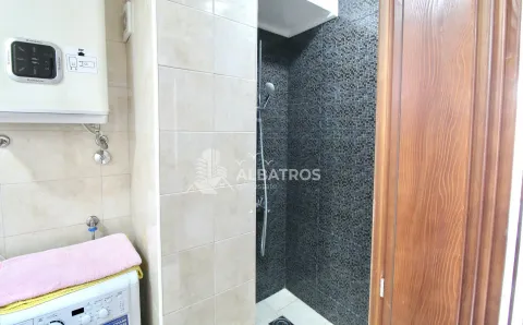 Smaller bathroom with a shower cabin and a water heater on the wall. - image 8