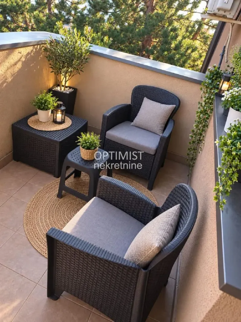 Namešten balkon sa garniturom za sedenje i ukrasnim biljkama.